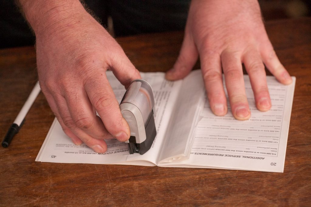 mechanic stamping logbook after successful logbook service